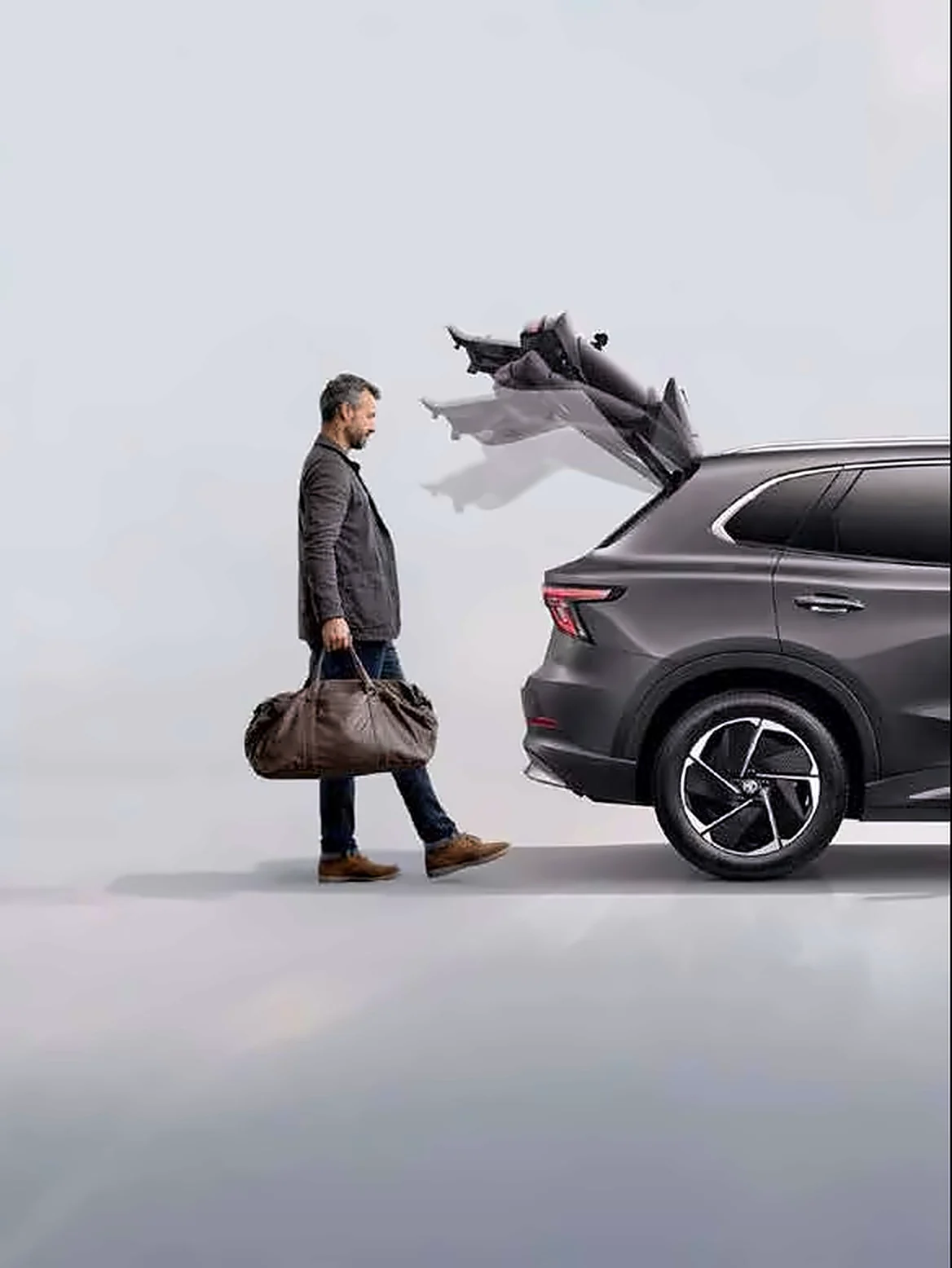 Person opening the power tailgate with a bag in hand Person opening the power tailgate with a bag in hand